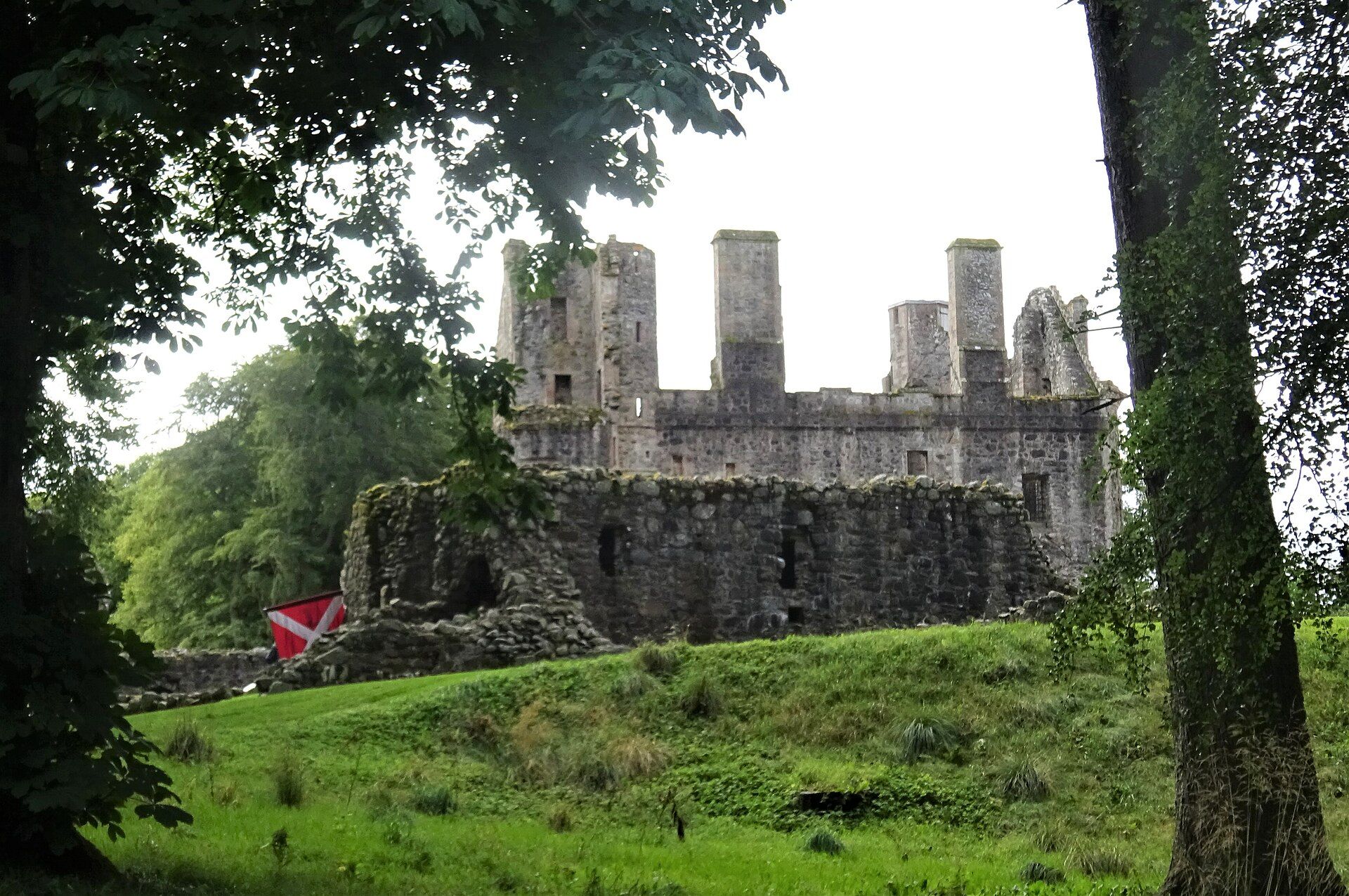 The ruined towers of Huntly Castle rising through trees.