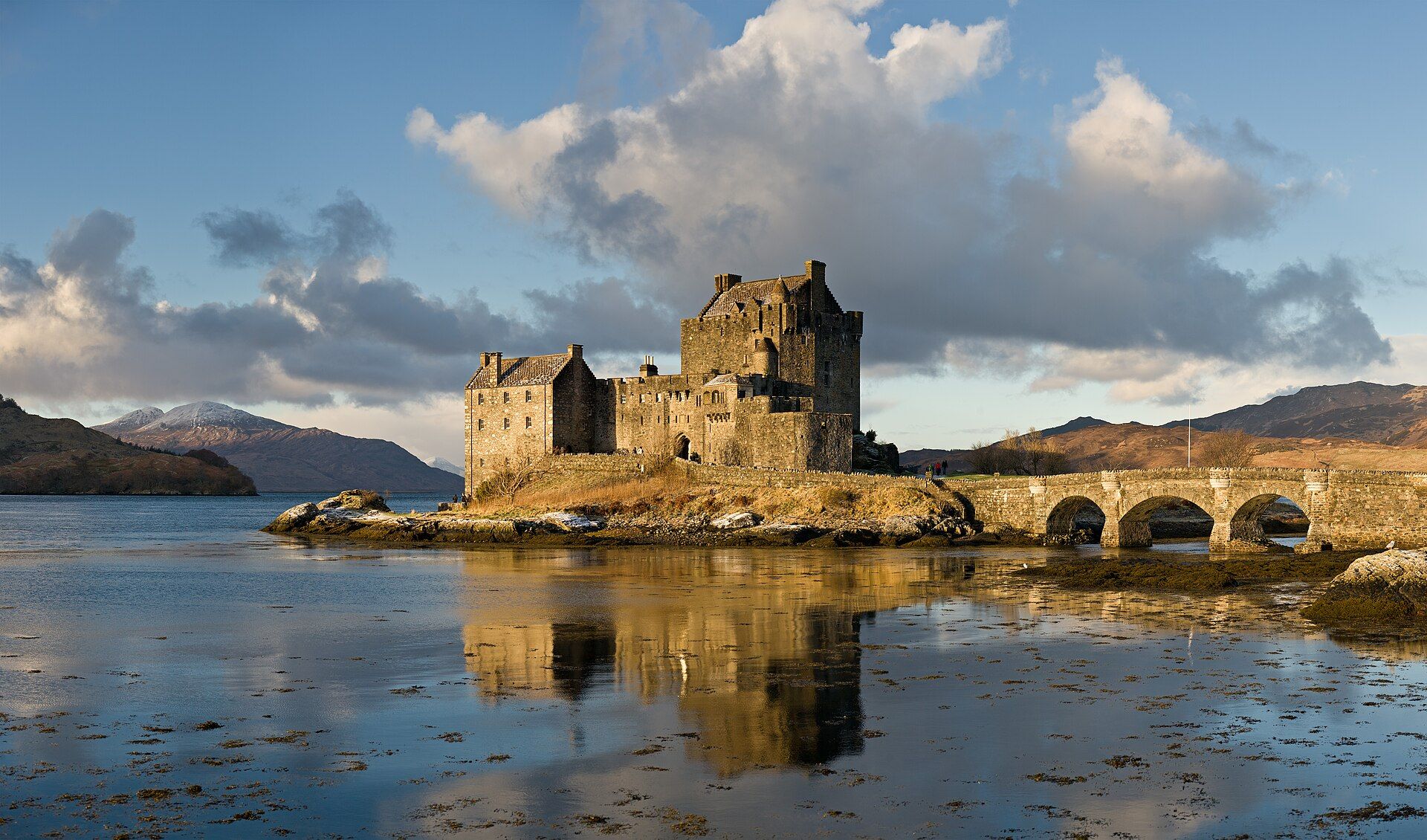 Eilean Donan Castle on its island at the meeting of three lochs, reached by a stone bridge.